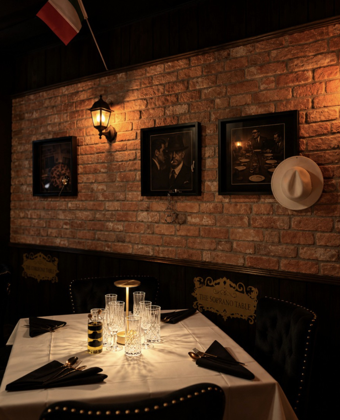 Candlelit table beneath the brick wall and Soprano Table sign